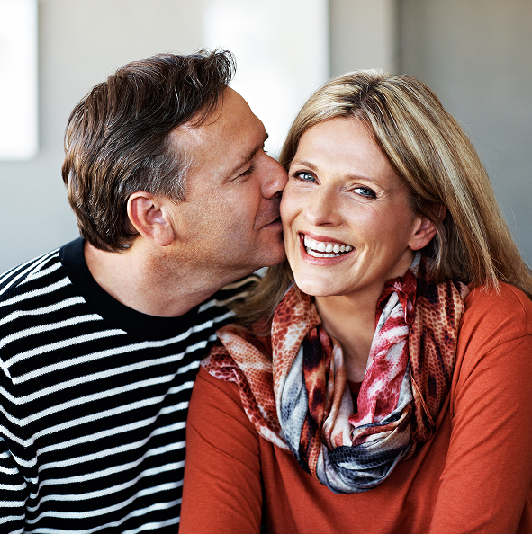 man kissing woman on cheek